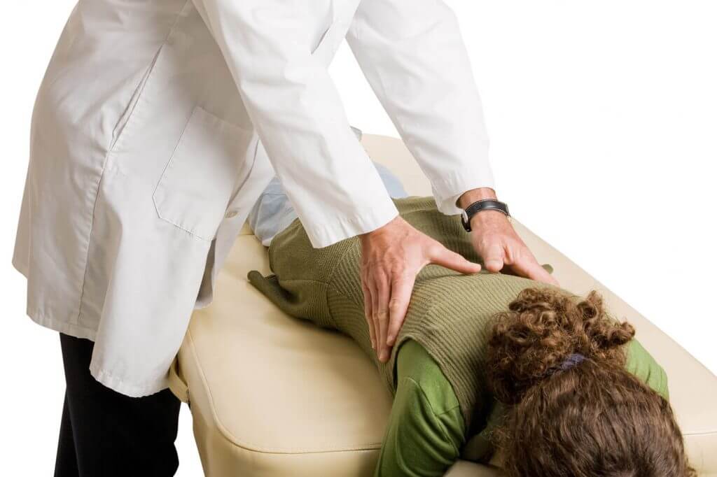 Woman getting adjusted by a chiropractor